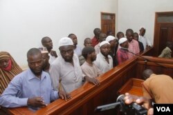 FILE - Murder suspects in the killing of Ugandan Police Commander Andrew Felix Kaweesi stand behind the dock at the Nakawa Chief Magistrates court in Kampala, Uganda, May 18, 2017. (H. Athumani/VOA)