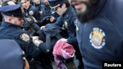 যুক্তরাষ্ট্রের অভিবাসন এজেন্টরা ফিলিস্তিনিপন্থি বিক্ষোভকারী মাহমুদ খলিলকে কলাম্বিয়া বিশ্ববিদ্যালয় থেকে গ্রেপ্তারের পর বিক্ষোভ শুরু হলে এক বিক্ষোভকারীকে আটক করে পুলিশ (১০ মার্চ, ২০২৫)