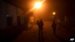 FILE - A migrant woman and two children begin their walk north from the community of La Lima in southern Veracruz state, Mexico, Nov. 24, 2021. 