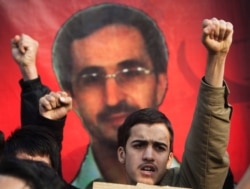Students shout slogans against Britain in front of a picture of the late Iranian nuclear scientist Majid Shahriari during a protest outside the British embassy in Tehran Dec. 12, 2010.