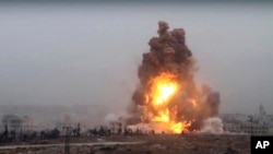 This frame grab from video provided by Thiqa news agency, a Syrian opposition media outlet that is consistent with independent AP reporting, shows flames rises from an explosive vehicle bomb that attacked a Syrian government position, in southwest of Alep