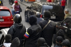 Masked members of a "colectivo" -pro-government cells- attend a rally in Caracas on Jan. 7, 2019.