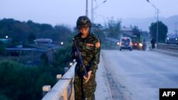 An army-linked militiaman secures a bridge in Muse, Myanmar, May 12, 2018.