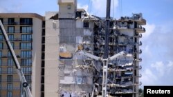 Search and rescue personnel continue searching for victims days after a residential building partially collapsed in Surfside, near Miami Beach, Florida, June 27, 2021. 