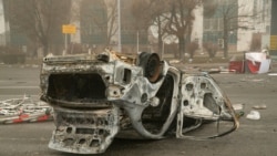 A burned-out automobile is seen on a square near an administrative quarter in central Almaty on Jan. 6, 2022.