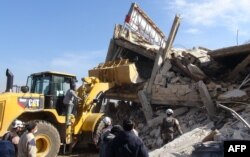 People gather around the rubble of a hospital supported by Doctors Without Borders (MSF) near Maaret al-Numan, in Syria's northern province of Idlib, on Feb. 15, 2016, after the building was hit by suspected Russian air strikes.