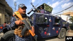 Iraqi federal police stand guard at a checkpoint in a street in the capital Baghdad on Jan. 29, 2021, during tightened security measures, a day after a man identified as the top Islamic State group figure in the country was killed.