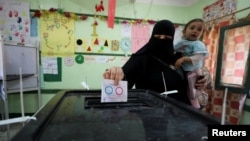 A woman casts her vote during the referendum on draft constitutional amendments, at a polling station in Cairo, Egypt, Apr. 20, 2019. 