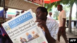 Un homme lit un journal tanzanien à Arusha, en Tanzanie, le 23 mars 2017.