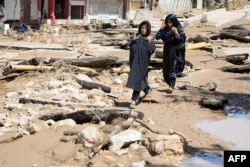An Iranian woman walks through a flooded street in the city of Poldokhtar in the Lorestan province, April 02, 2019.