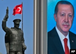 A statue of modern Turkey's founder Mustafa Kemal Ataturk and a poster of Turkey's President Recep Tayyip Erdogan for the upcoming referendum is seen in his hometown city of Rize, April 4, 2017.