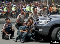 Police officers react near the site of a blast in Jakarta, Indonesia, Jan. 14, 2016.