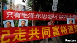 资料照：中国毛派人士手举毛泽东画像和标语横幅在广州南方周末报社外举行抗议集会。（2013年1月9日）