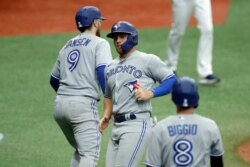 Toronto Blue Jays' Brandon Drury celebrates with Danny Jansenafter scoring on a two run single by Bo Bichette off Tampa Bay Rays relief pitcher Andrew Kittredge during the sixth inning of a baseball game, July 26, 2020, in Petersburg, Fla.