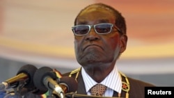 FILE - President Robert Mugabe waits to address crowds gathered for Zimbabwe's Heroes Day commemorations in Harare, Aug. 10, 2015.