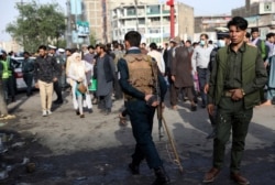 Afghan security personnel inspect the site of a deadly bomb explosion in Kabul, Afghanistan, July 13, 2021.
