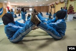 Two women practice a pose during a mind-body wellness program for survivors of trauma in Mogadishu, Somalia, Jan. 16, 2017. (J. Patinkin/VOA)