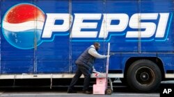 FILE - In this Feb. 9, 2012 file photo, Kandral McKenzie delivers Pepsi products in New York. PepsiCo reports quarterly earnings Wednesday, Oct. 16, 2013. (AP Photo/Mark Lennihan, File)