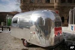 Shiny Airstreams come in all sizes. Here's a tiny one. Kind of doubt this one has all the comforts of home.