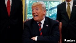 U.S. President Donald Trump talks to reporters about the killing of journalist Jamal Khashoggi in Turkey during a bill-signing ceremony at the White House in Washington, Oct. 23, 2018. 