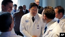 Dr. Dicken Ko, director of Massachusetts General Hospital's urology program, shakes hands with surgical team members after a news conference at the hospital in Boston to announce the first penis transplant in the United States, May 16, 2016.