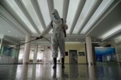 FILE - A health worker sprays disinfectant as part of preventative efforts against COVID-19, at the Okryu restaurant in Pyongyang, Oct. 21, 2020.