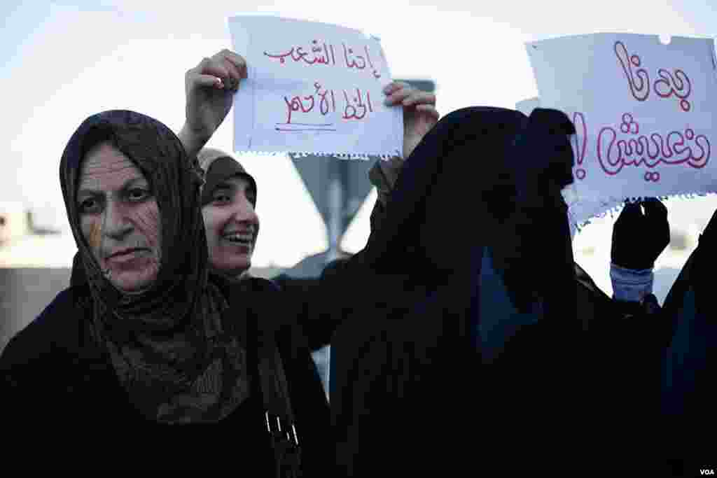 Protesters held up signs on the edge of Interior Ministry Circle in Amman. (Y. Weeks for VOA)
