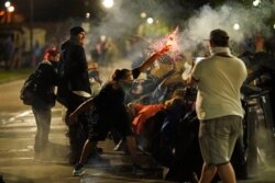 A protester tosses an object toward police during clashes outside the Kenosha County Courthouse late Tuesday, Aug. 25, 2020, in Kenosha, Wis., on third night of unrest following the shooting of a Black man, Jacob Blake.
