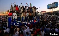 Sudanese demonstrators chant slogans as they attend a mass anti-government protest outside Defence Ministry in Khartoum, April 21, 2019.