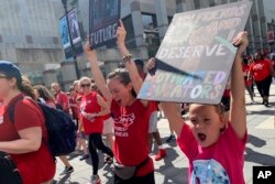 Zoë Powell, 8, leads a chant of "Whose school? Our school!" alongside of her mother, Sarah Jackson, 24, on May 1, 2019, who is a special education teacher at Green Elementary School in Raleigh, North Carolina.