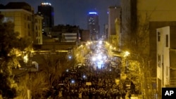 Iranian police officers take position while protesters gather in front of Amir Kabir University in Tehran, Iran, Jan. 11, 2020, to remember victims of a Ukrainian airliner shot down by an Iranian missile. 