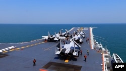 资料照：中国海军舰队在东中国海举行了“实弹演习”期间，航空母舰辽宁号上载有的歼15战机。（2018年4月24日）