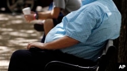 FILE - An overweight man rests on a bench in Jackson, Mississippi. Rising numbers of American adults have the most dangerous kind of obesity, belly fat, despite evidence that overall obesity rates may have plateaued, government data shows. 