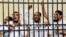 Supporters of the Muslim Brotherhood and other Islamists call out from the defendants cage as they receive sentences ranging from death by hanging for one, life in prison for 13 and 8-15 years for the others after they were convicted of murder, rioting, and violence in a mass trial in Alexandria, Egypt, May 19, 2014.