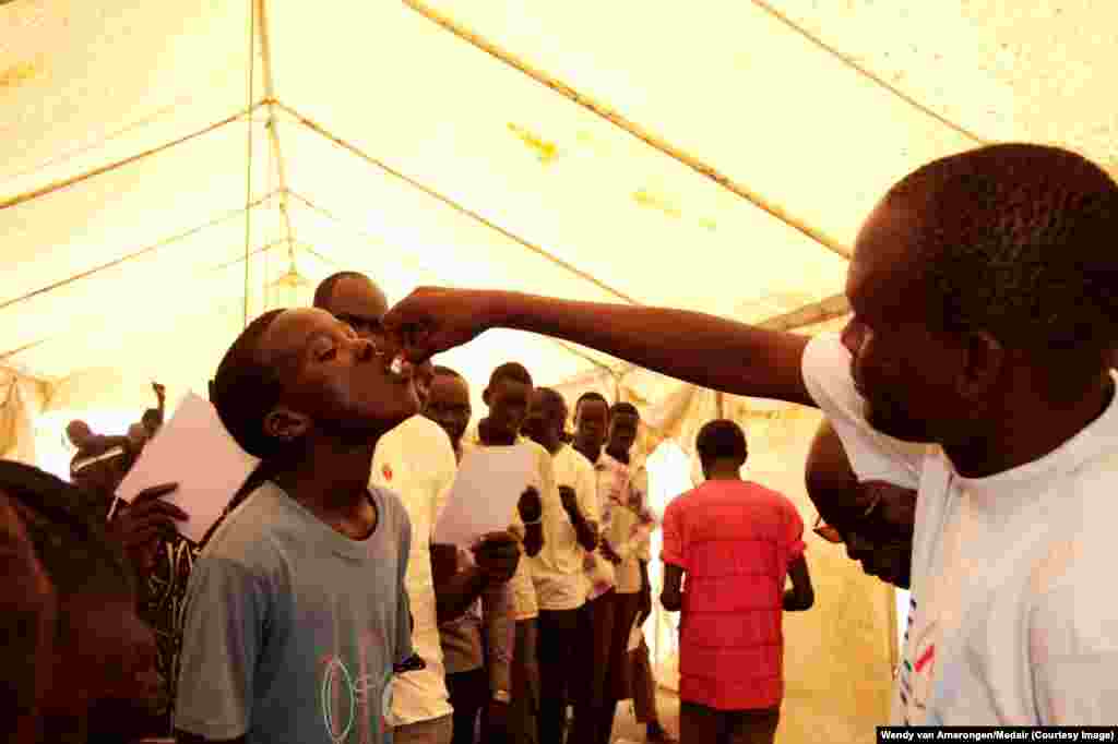A displaced youth is given a dose of oral cholera vaccine at the Tomping UNMISS base in Juba. Faith-based humanitarian group Medair along with the South Sudan Ministry of Health, WHO, UNICEF and MSF are vaccinating IDPs pre-emptively against cholera.