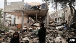 Children stand amid the rubble of a building destroyed by Israeli bombing in Rafah, Gaza, on Jan. 27, 2024.