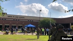 Policías responden a un tiroteo en la escuela secundaria Santa Fe en Texas el viernes, 18 de mayo, de 2018.