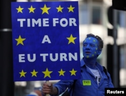 A protester holds a banner before an anti-Brexit demonstration, in central London, Britain, Oct. 20, 2018.