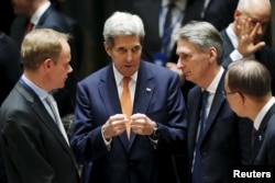 FILE - From left, British Ambassador to the U.N. Matthew Rycroft, U.S. Secretary of State John Kerry, Britain's Foreign Secretary Philip Hammond, U.N. Secretary General Ban Ki-moon speak before a meeting of the U.N. Security Council in New York, Dec. 18, 2015.