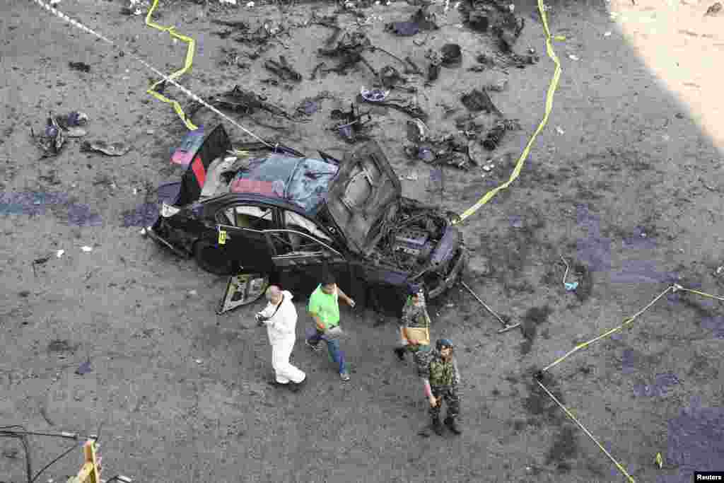 An inspector and Lebanese soldiers work at a site of an explosion in the southern suburbs of Beirut, June 24, 2014.