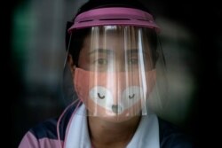 A volunteer wearing a face shield and mask manages a counter of COVID-19 infection screening center at the Chulalongkorn University health service center in Bangkok, Thailand, April 1, 2020.