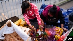 Mujeres recogen productos desechados en el mercado central de frutas y verduras en Buenos Aires, Argentina, el viernes 10 de mayo de 2024.