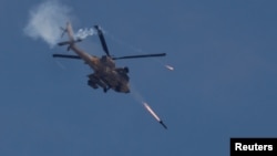 An Israeli military Apache helicopter fires missiles towards Gaza, amid the ongoing conflict between Israel and the Palestinian Islamist group Hamas, as seen from southern Israel, May 14, 2024.