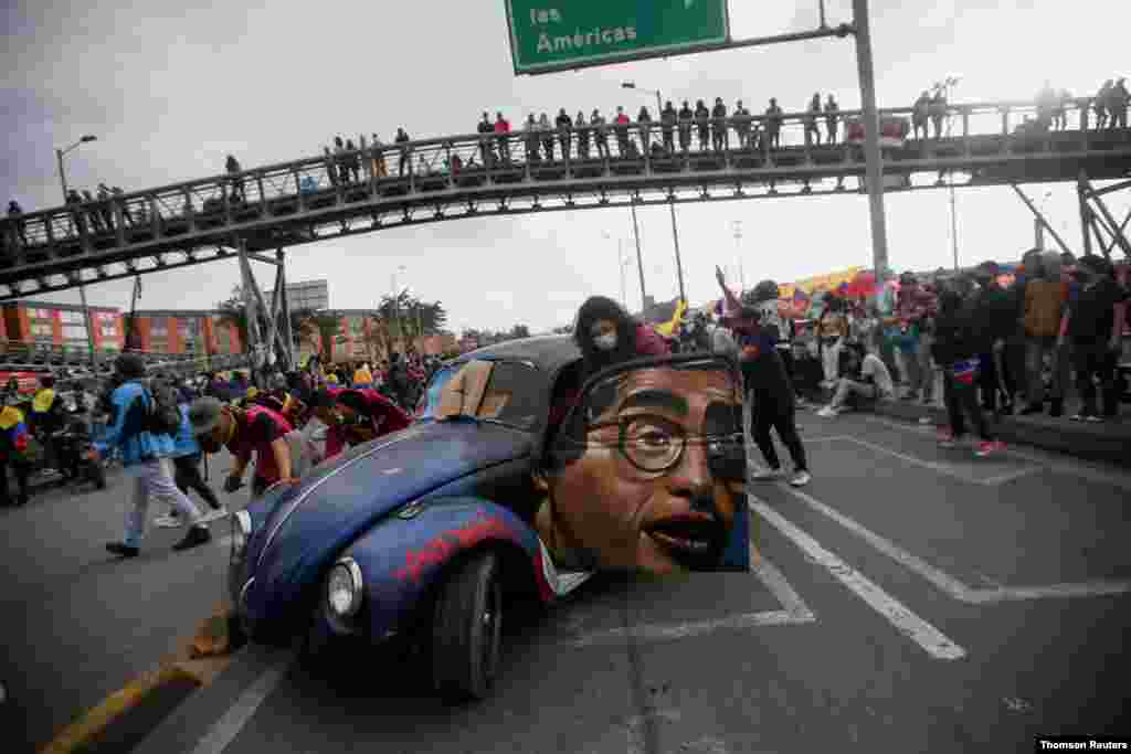 Personas empujan un automóvil con la imagen del difunto humorista y periodista colombiano Jaime Garzón durante una protesta para exigir acciones del gobierno para abordar la pobreza, la violencia policial y las desigualdades.