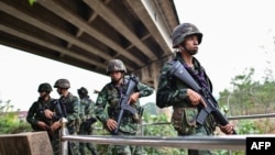 Thai military personnel stand guard overlooking the Moei river on the Thai side, near the Tak border checkpoint with Myanmar, in Thailand's Mae Sot district on April 10, 2024.