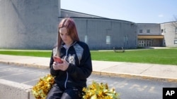 FILE - Brandi Levy wears her cheerleading outfit as she looks at her mobile phone outside Mahanoy Area High School in Mahanoy City, Pa., April 4, 2021. (American Civil Liberties Union photo)