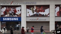 Cư dân xếp hàng giữ khoảng cách bên ngoài mội siêu thị ở Vũ Hán ngày 3/4/2020.