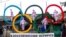 FILE - Exile Tibetans use the Olympic rings as a prop as they protest the holding of the 2022 Winter Olympics in Beijing, in Dharmsala, India, Feb. 3, 2021. 