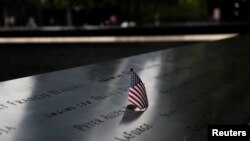 Una bandera estadounidense es colocada en uno de los nombres en la fuente reflectante en el Monumento conmemorativo del 11 de Septiembre en la ciudad de Nueva York.