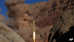 FILE - In this photo obtained from the Iranian Fars News Agency, a Qadr H long-range ballistic surface-to-surface missile is fired by Iran's powerful Revolutionary Guard, during a maneuver, in an undisclosed location in Iran.